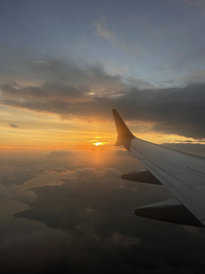 Sunset over the clouds from a plane window
